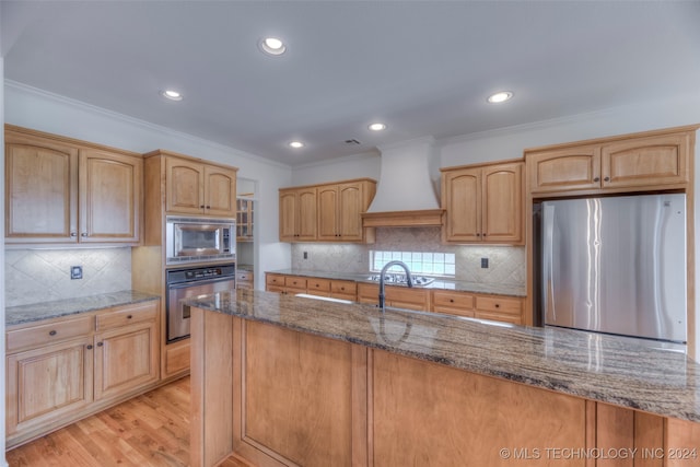 kitchen featuring custom exhaust hood, decorative backsplash, light hardwood / wood-style flooring, and stainless steel appliances