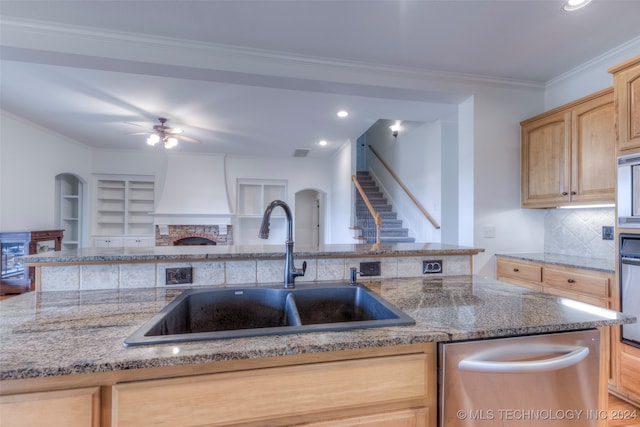 kitchen with sink, light brown cabinetry, tasteful backsplash, dishwasher, and ceiling fan