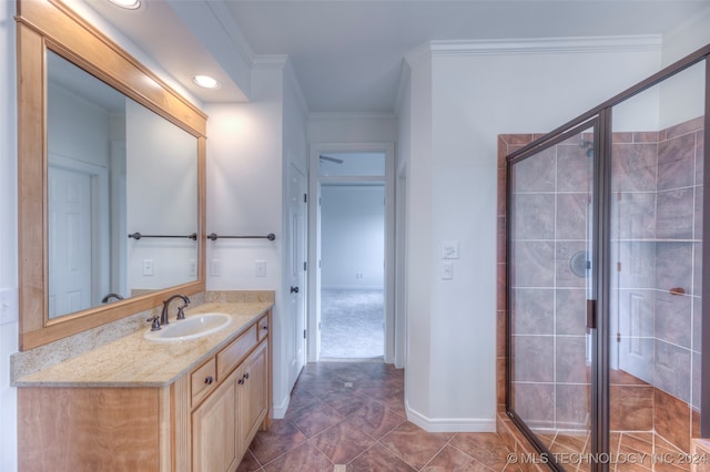 bathroom featuring ornamental molding, walk in shower, tile patterned flooring, and vanity