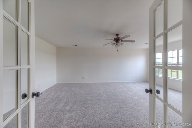 carpeted empty room with ceiling fan and french doors