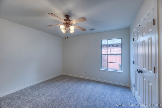 carpeted spare room featuring ceiling fan