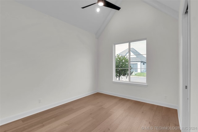 empty room with ceiling fan, high vaulted ceiling, and light hardwood / wood-style flooring