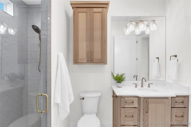 bathroom featuring toilet, vanity, and a shower with shower door