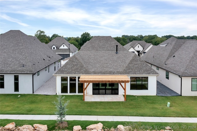 rear view of property featuring a lawn