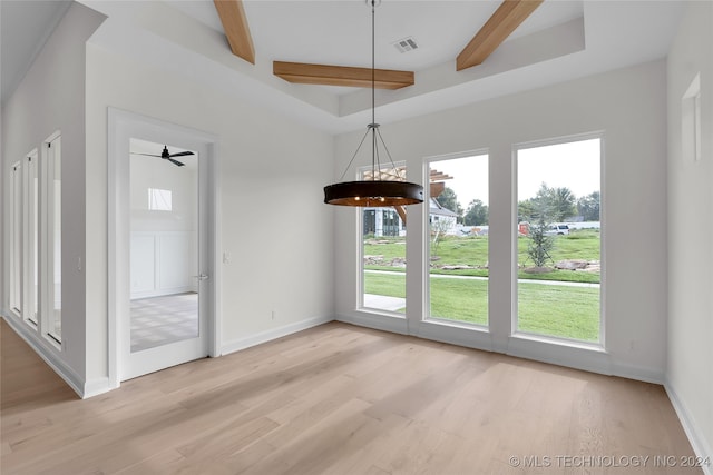 unfurnished dining area with beamed ceiling, light hardwood / wood-style flooring, and ceiling fan