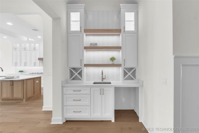 interior space featuring white cabinetry, backsplash, and light hardwood / wood-style flooring