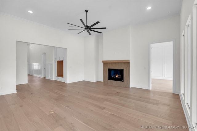 unfurnished living room featuring light hardwood / wood-style floors, ornamental molding, and ceiling fan