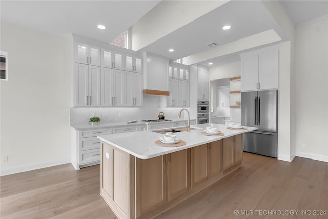 kitchen featuring white cabinets, light hardwood / wood-style floors, sink, a center island with sink, and stainless steel appliances