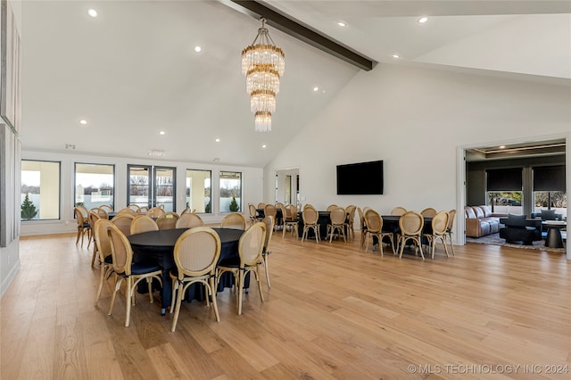 dining space with a wealth of natural light, light hardwood / wood-style flooring, beamed ceiling, and a chandelier