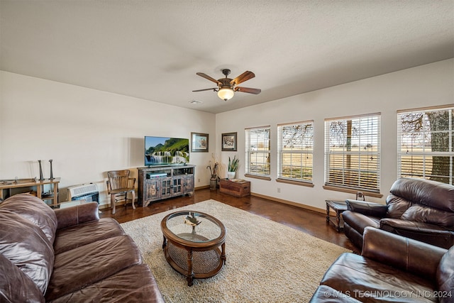 living area with visible vents, a textured ceiling, a ceiling fan, and baseboards