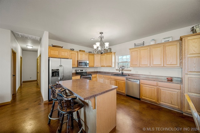 kitchen featuring visible vents, a kitchen island, appliances with stainless steel finishes, hanging light fixtures, and a sink