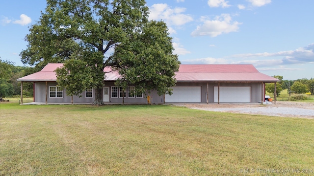 ranch-style house with a front yard, metal roof, and driveway