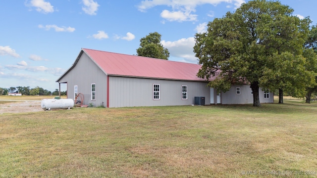 view of property exterior featuring central AC unit and a lawn