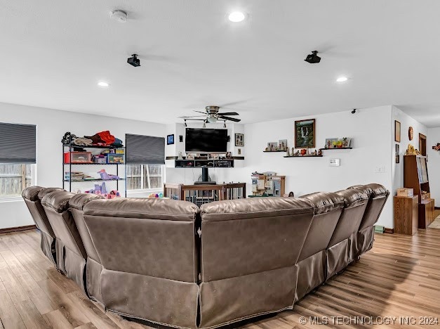 living room featuring ceiling fan and light hardwood / wood-style floors