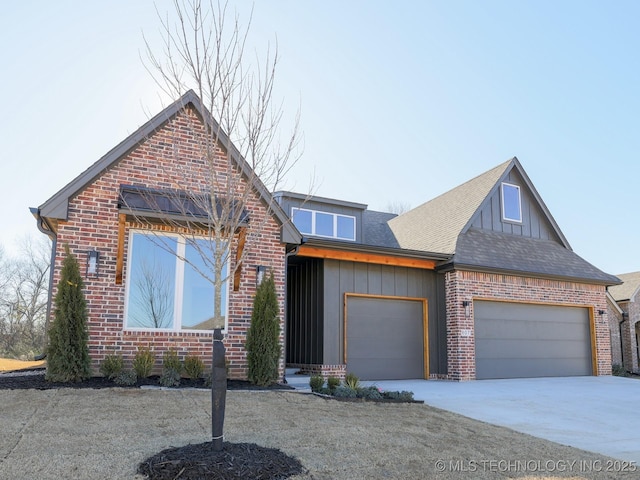 view of front of property with a garage, brick siding, driveway, and board and batten siding