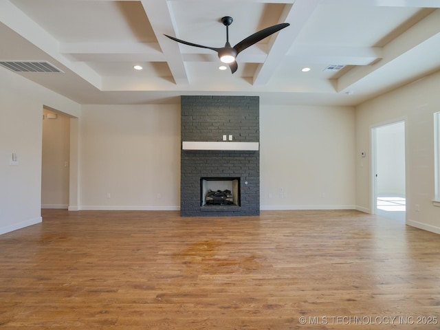 unfurnished living room with light wood finished floors, visible vents, coffered ceiling, a ceiling fan, and a brick fireplace