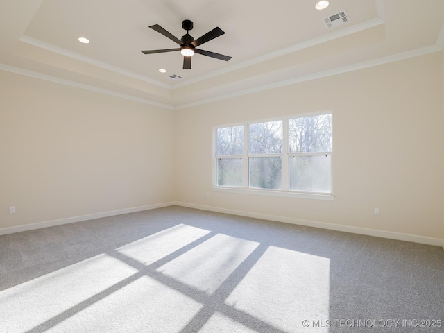 carpeted empty room with baseboards, crown molding, visible vents, and a tray ceiling