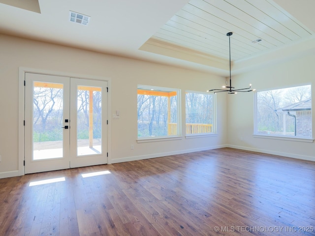 807 E Jacksonville St, Broken Arrow, OK 74012 - unfurnished dining area with a raised ceiling, a chandelier, wood finished floors, french doors, and baseboards