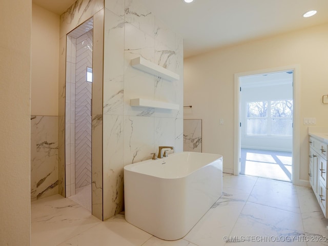 bathroom with marble finish floor, a soaking tub, vanity, and recessed lighting