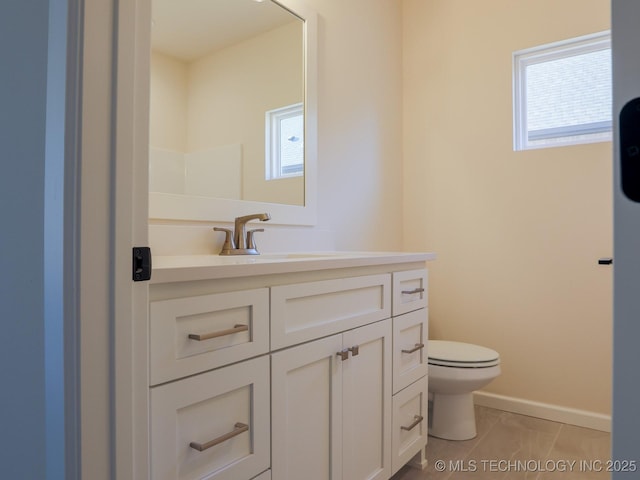 bathroom featuring tile patterned flooring, baseboards, vanity, and toilet