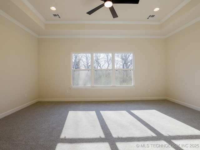 carpeted spare room with a raised ceiling, visible vents, crown molding, and baseboards