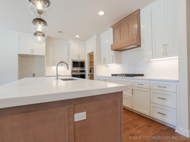 807 E Jacksonville St, Broken Arrow, OK 74012 - kitchen with a sink, stainless steel appliances, decorative backsplash, white cabinetry, and wood finished floors