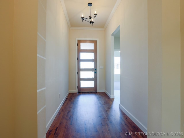 interior space with a notable chandelier, baseboards, dark wood finished floors, and crown molding