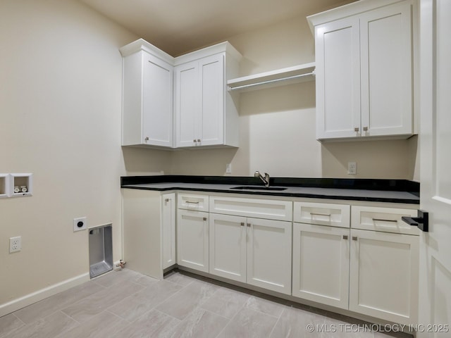 clothes washing area featuring washer hookup, a sink, baseboards, cabinet space, and electric dryer hookup