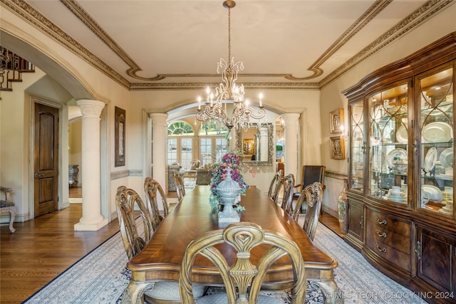 dining area featuring a notable chandelier, ornate columns, ornamental molding, and wood-type flooring