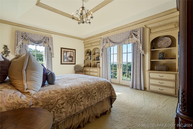 carpeted bedroom with an inviting chandelier, access to outside, french doors, and a tray ceiling