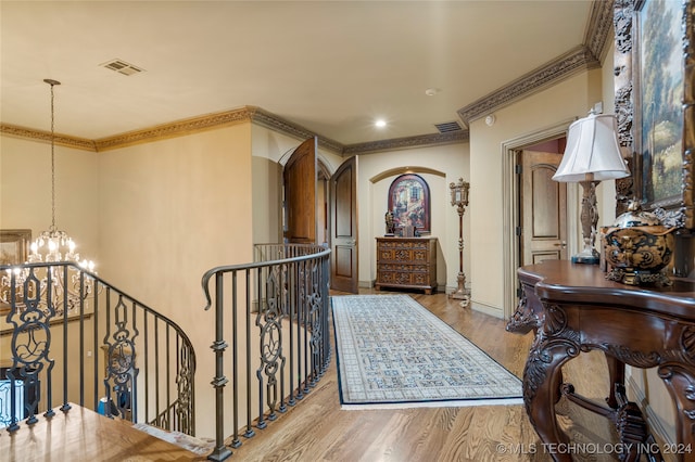 entrance foyer featuring light wood-type flooring, crown molding, and a chandelier