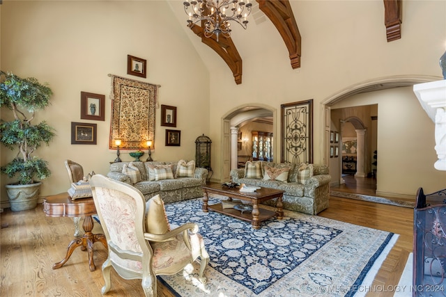 living room featuring a notable chandelier, high vaulted ceiling, and wood-type flooring