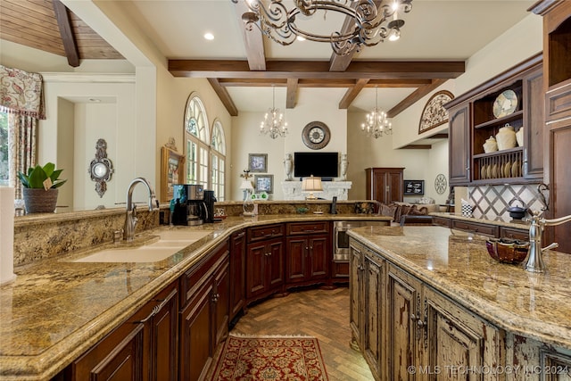 kitchen with beamed ceiling, sink, plenty of natural light, and light stone countertops