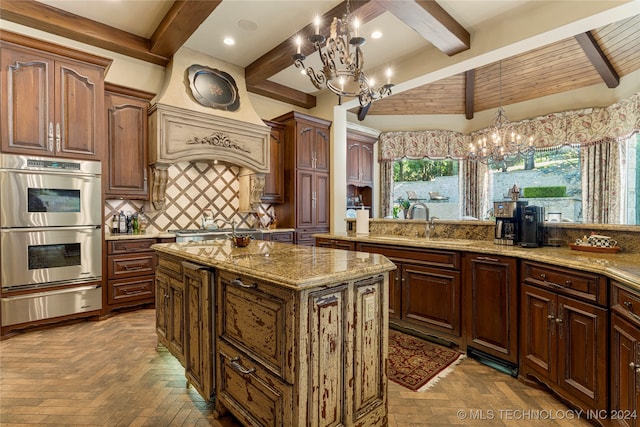 kitchen featuring beam ceiling, stainless steel appliances, sink, a kitchen island, and parquet floors