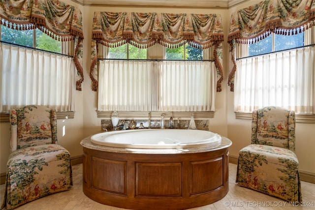 bathroom featuring a wealth of natural light, a tub to relax in, and tile patterned floors