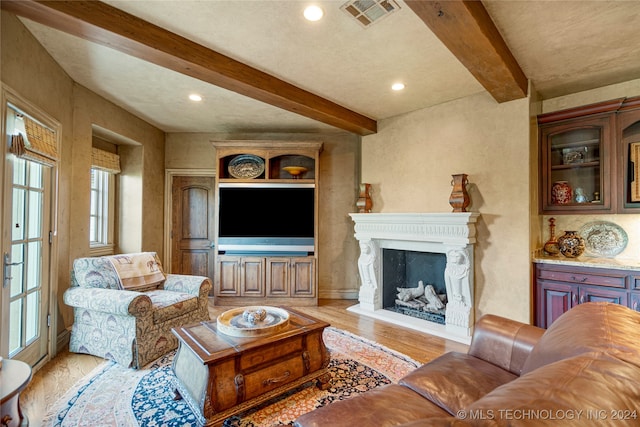 living room with light hardwood / wood-style floors and beamed ceiling