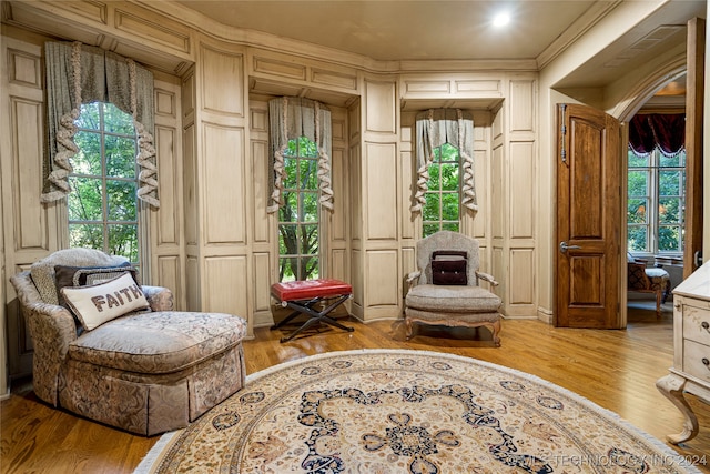 sitting room with a wealth of natural light, light hardwood / wood-style flooring, and ornamental molding