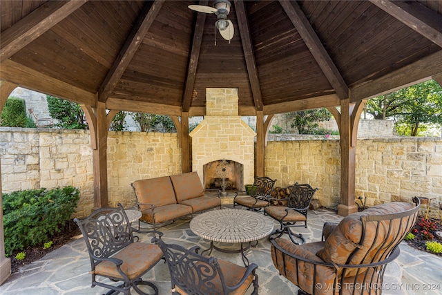 view of patio featuring a gazebo and an outdoor stone fireplace