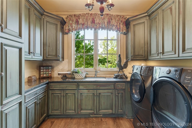 laundry room featuring light wood-type flooring, cabinets, independent washer and dryer, sink, and crown molding