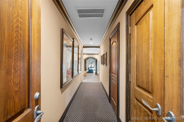 hallway with carpet floors and crown molding