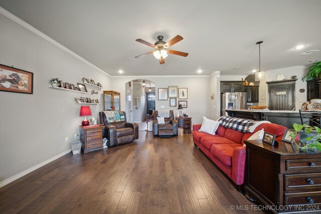 living room featuring ceiling fan, ornamental molding, and dark hardwood / wood-style floors