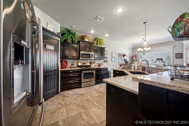 kitchen featuring appliances with stainless steel finishes, dark brown cabinets, sink, light stone counters, and tasteful backsplash