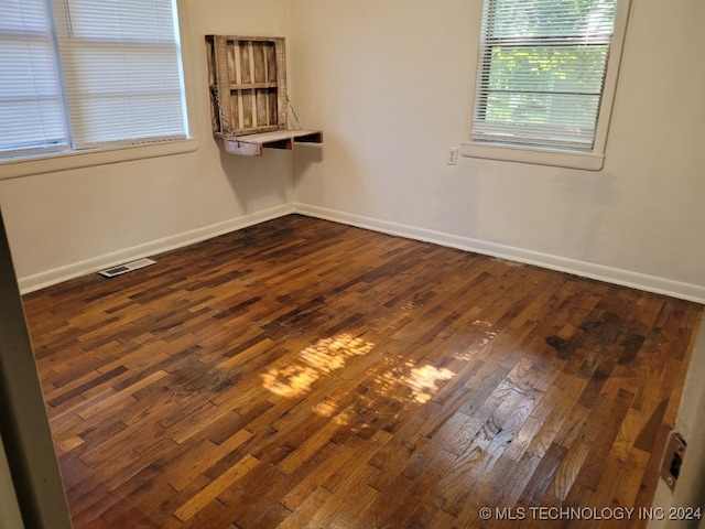 spare room with dark hardwood / wood-style flooring