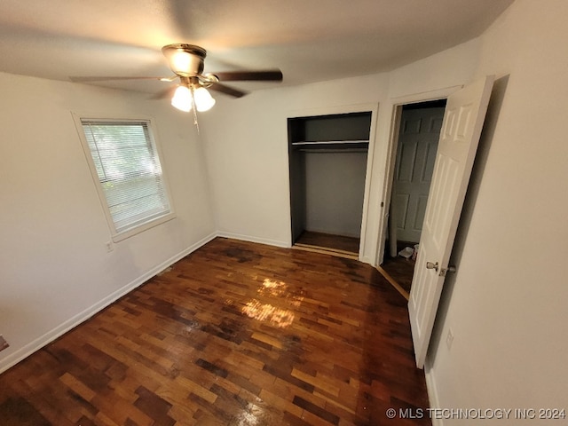 unfurnished bedroom with ceiling fan, a closet, and dark wood-type flooring