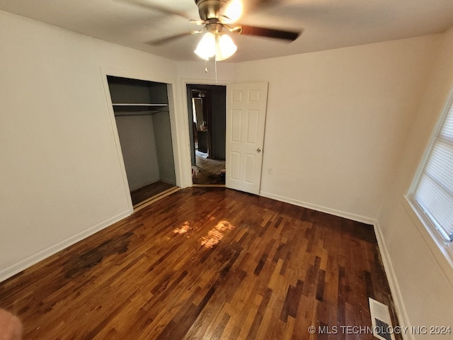 unfurnished bedroom with ceiling fan, a closet, and wood-type flooring