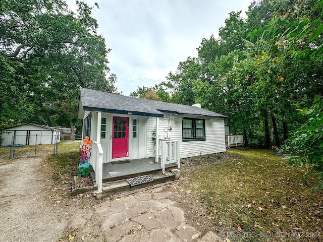 view of front of house with an outdoor structure, a garage, and a front lawn