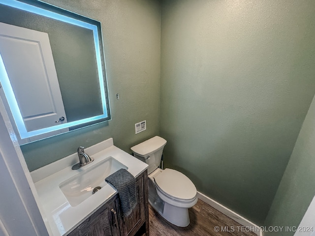 bathroom with toilet, hardwood / wood-style flooring, and vanity