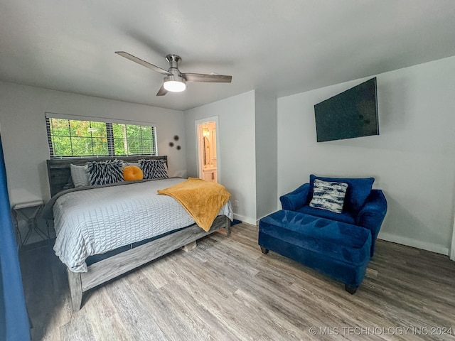 bedroom featuring ceiling fan, ensuite bath, and hardwood / wood-style flooring