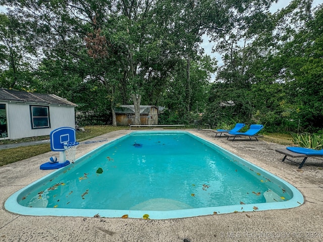 view of pool with a storage shed