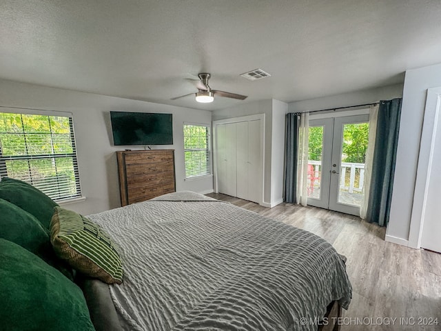 bedroom with french doors, light wood-type flooring, a closet, access to outside, and ceiling fan